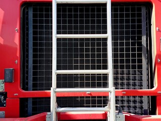 The engine cooling radiator of a special fire truck, in front of which a metal ladder is installed....