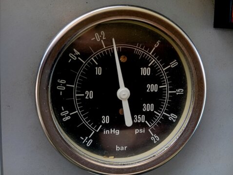 A special device that determines the pressure and degree of rarefaction of the air. Vacuum gauge and manometer in one device. Manometer scale with white divisions and arrow.