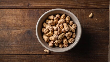 Peanuts in plates on a wooden background. Top view, empty space