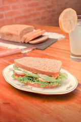 Sandwich on a Plate with Lemon Juice and a Bread on a Counter