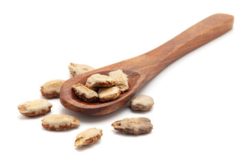 Front view of a wooden spoon filled with Organic Snake Gourd (Trichosanthes cucumerina) seeds. Isolated on a white background.