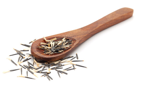 Front view of a wooden spoon filled with Organic Orange Marigold (Tagetes patula) seeds. Isolated on a white background.