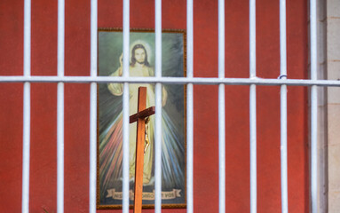Jesus am Holzkreuz hinter Gitterstäben, Barcelona, Spanien