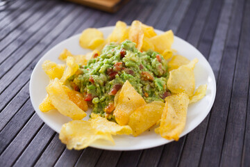 Delicious appetizer on a plate. Guacamole with chips - 803345053