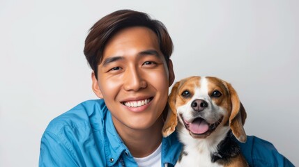 A young Asian man with short dark brown hair is smiling next to a beagle dog