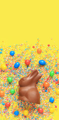 Chocolate bunny and colored sugar sprinkles on a yellow background, top view. Easter composition....