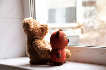 Children's soft toys sit on the window and look out the window