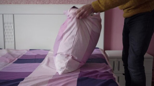 man changes the pillow, bachelor changes the pillowcase in the pillow, housework
