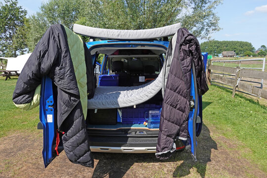 Schlafsack und Matratze trocknen an der Heck T&uuml;r eines Mini Camper Van am Morgen in der Sonne