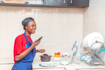Happy African Woman Receives Exciting Phone Call in Modern Kitchen