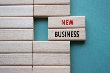 New business symbol. Concept words New business on wooden blocks. Beautiful grey green background....
