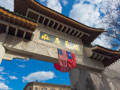 Chinatown Gateway Paifang with US national flag and Republic of China (Taiwan) flag hanging on, in Chinatown district of Boston, Massachusetts MA, USA.