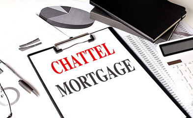 CHATTEL MORTGAGE text on clipboard on chart with notebook and calculator