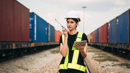 Supervisor inspecting inventory or task information on freight train cars and shipping containers....