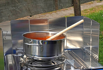 Eine Suppe kocht in einem Topf auf einen Gaskocher. Outdoor Küche