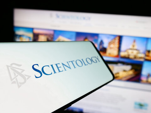 Stuttgart, Germany - 04-15-2024: Smartphone with logo of religious organisation Scientology in front of website. Focus on left of phone display.