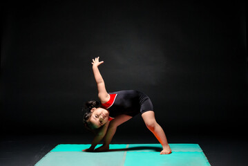 The beautiful Latin girl touches her foot with her hand, during warm-up exercises in her Olympic gymnastics class.