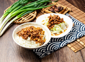Pork Rice with Blanched vegetables, spring onion, spoon and chopsticks served in bowl isolated on napkin side view on table taiwan food