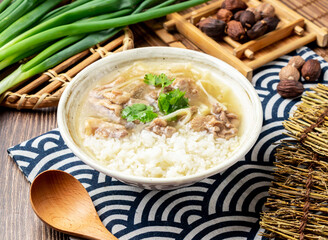 Stir fried duck meat with rice with spring onion, spoon and chopsticks served in bowl isolated on napkin side view on table taiwan food