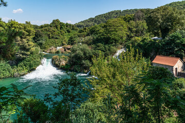 Fototapeta na wymiar Krka River Flowing Through Lush Green Forest in Krka National Park, Croatia