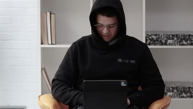 young computer hater or pirate typing on laptop