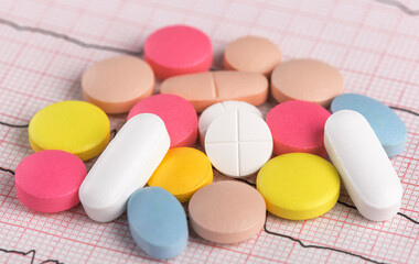 medical pills on the background of a cardiogram