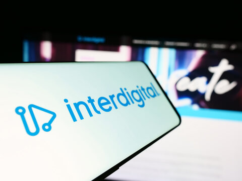 Stuttgart, Germany - 04-18-2024: Mobile phone with logo of American technology company InterDigital Inc. in front of business website. Focus on center-left of phone display.