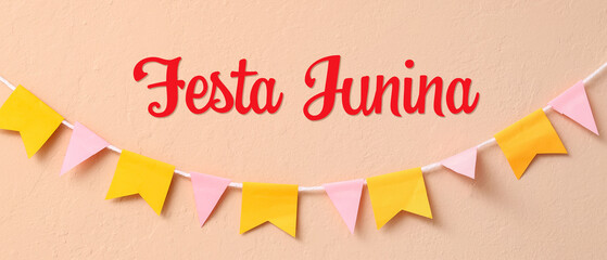 Colorful flags for Festa Junina on beige wall