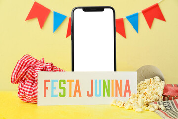 Tasty popcorn with bundle bag and text FESTA JUNINA on color background