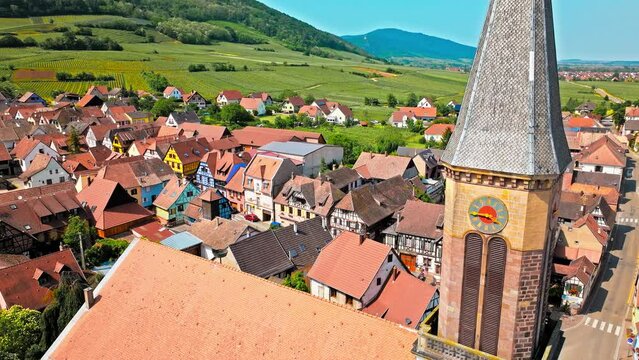 Aerial view of the French-style cathedra with a clock and colourful houses in Kintzheim, France. Wine-growing village in a commune in the Bas-Rhin department in Alsace in north-eastern France