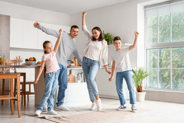 Happy family dancing in kitchen