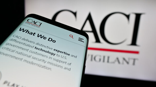 Stuttgart, Germany - 04-28-2024: Smartphone with website of US information technology company CACI International Inc. in front of logo. Focus on top-left of phone display.