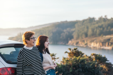 Portrait of a mother and daughter chatting and smiling while taking a break from a road trip at a...