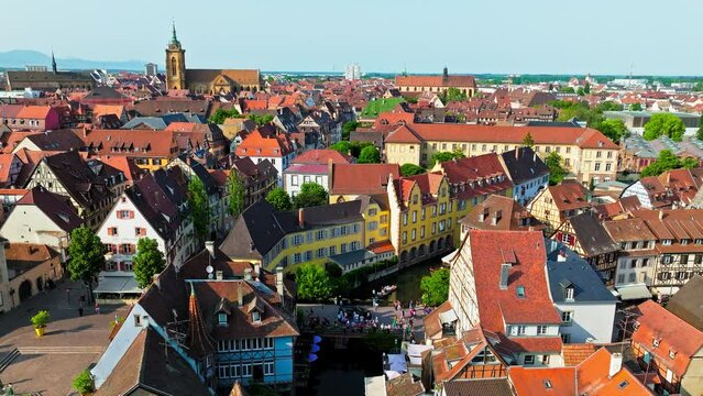 Aerial view of Le Petite Venise Alsatian half-timbered houses along riverbanks in Colmar. Tourists visit the Historical landmark Little Venise by the bridge with colourful houses in Colmar, France.