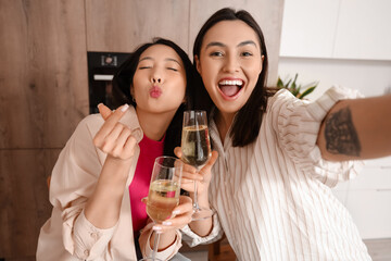 Young women with champagne taking selfie at Hen Party in kitchen, closeup