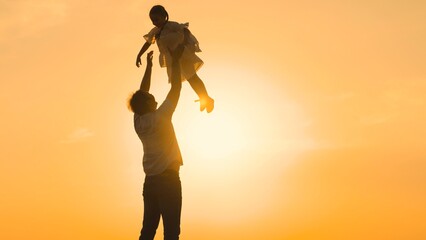 father throws child kid daughter into sky, silhouette happy family, children dream flying airplane...