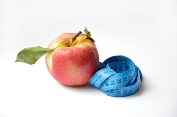 red apple and soft centimeter on a white background. diet and proper nutrition. fight against excess weight. measuring the volume of body parts