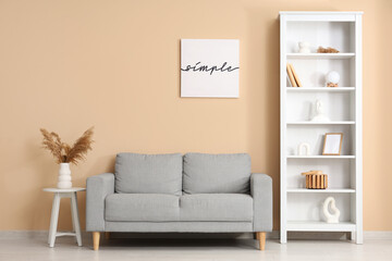 Stylish interior of modern living room with sofa, table and shelving unit