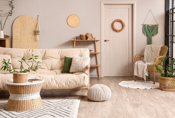 Interior of light living room with bamboo stems on coffee table and white sofa