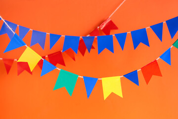 Colorful garlands for Festa Junina celebration on color background