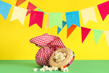 Mini sombrero with popcorn, bundle bag and flags for Festa Junina celebration on table against...