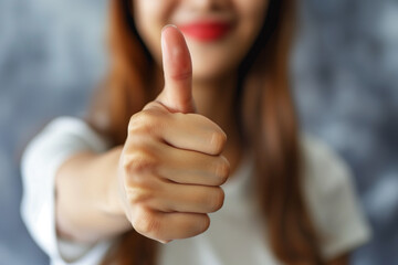 Positive Gesture with Thumbs Up. Close-up of a woman giving a thumbs up, symbolizing approval, satisfaction, or positive feedback, isolated on a blurred background.