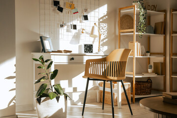 Interior of living room with workplace, pin board and plants