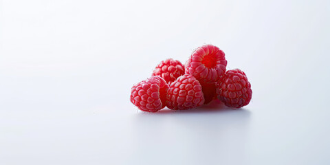 A cluster of raspberries takes center stage against a clean white background.