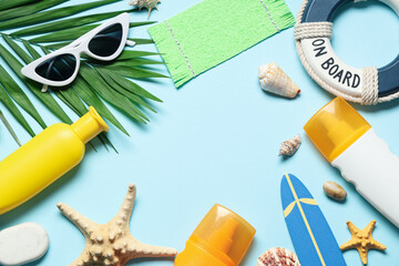 Frame made of sunscreen cream, sunglasses and decor on color background