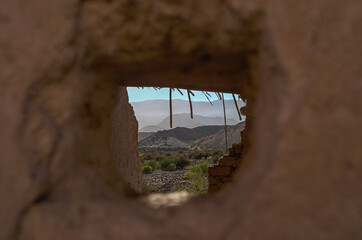 vintage mud house with mountains in the background
