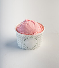 Single scoop strawberry ice cream in a paper glass cup