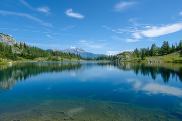 Fototapeta na wymiar An image of a serene mountain lake reflecting a clear blue sky, capturing the beauty of stillness.