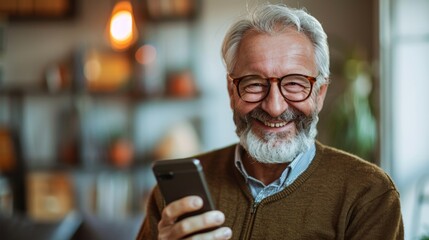 Senior Caucasian man smiling while using a smartphone in a stylish, well-lit home environment.