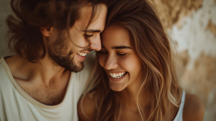 A candid waist-length perspective image featuring a couple smiling lovingly at each other against a plain background, their eyes filled with warmth and adoration as they share a mo
